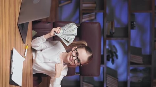 Confident Girl Holds Money at Desk
