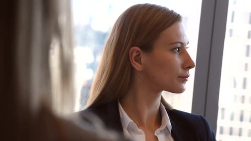 Blonde business woman in a meeting with her colleagues listening intently to the ongoing discussion