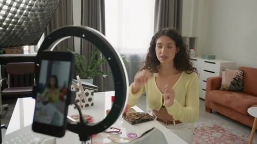 Mujer habla sobre la brocha de maquillaje mientras filmaba un vlog de belleza en un estudio doméstico
