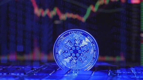 A Cardano ADA crypto currency coin rotating on a mining rig of computer chips with exchange charts i