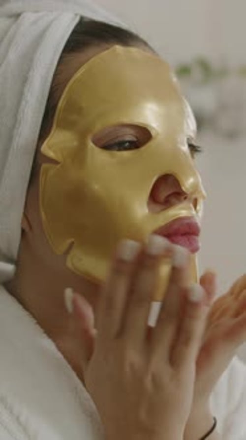 Woman Smoothing Collagen Mask on Face
