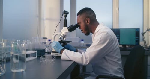 Scientist Using Microscope in Modern Bright Laboratory