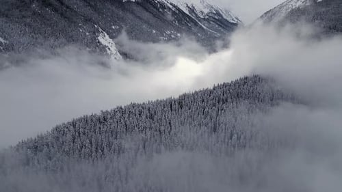 Majestic Snowy Mountains Rise Above Misty Valleys in a Tranquil Winter Landscape