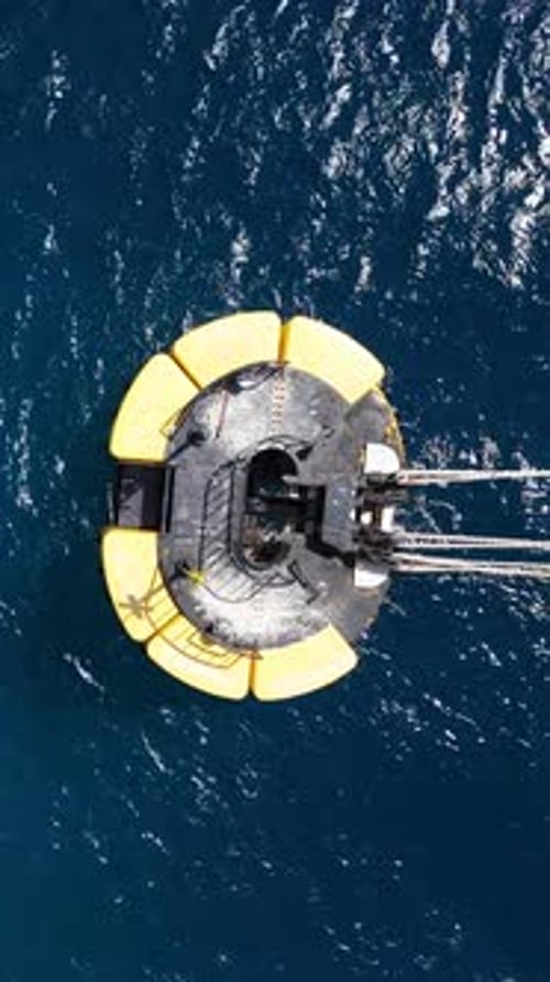 Drone top down shot on yellow mooring buoy in deep blue Caribbean ocean, small waves and wind ripple