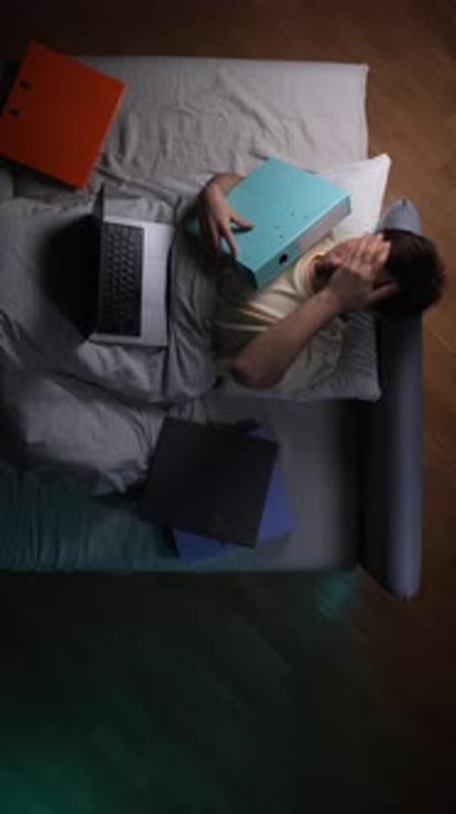 Man Overwhelmed with Work Lying on Sofa