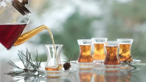 Tea being poured into glass on table