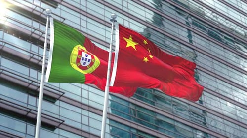 Portugal and China Flags Waving Against Modern Corporate Building