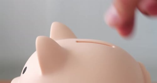 Hand Put Coin Into Piggy Bank for Saving Money and Business Investment Concept