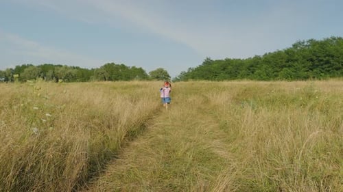 Joyful Preadolescent Girl in Superhero Costume and Mask Running on Field