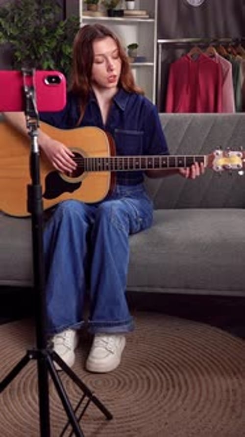 Young Woman Playing Acoustic Guitar at Home