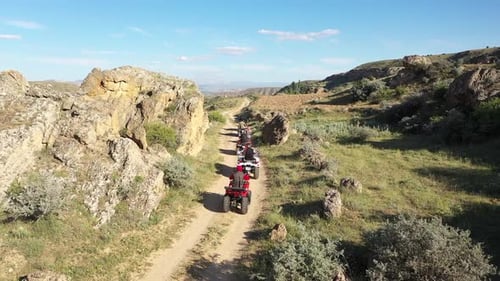 Des conducteurs de VTT conduisant hors route le long d'une route de montagne avec une vue aérienne