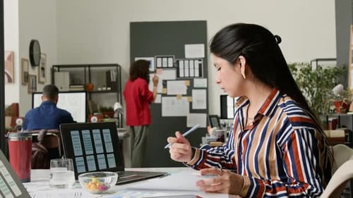 Hispanic Female UI Designer Working on New Mobile Application in Office