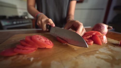 Cutting Tomato on Cutting Board with Knife