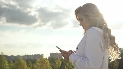 Blond Woman Using Smartphone in Urban Environment
