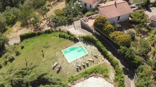 Nice Helix Drone View of a Private Swimming Pool in Italy, White Woman Laying on a Floating Pineaple