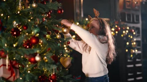 Child Decorating a Christmas Tree with Ornaments
