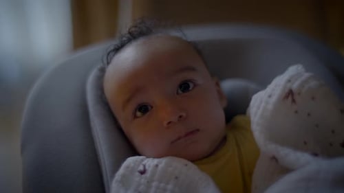 Sweet Infant Lying in Bouncer Seat with Blanket