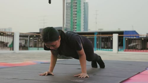 Woman Doing Yoga and Pushups on City Rooftop