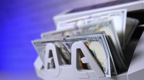 Counting hundred of dollar bills in bank. Financial operation on electronic cash counting machine