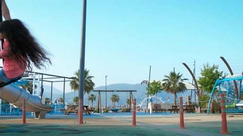 Child Swinging on Playground Overlooking Ocean