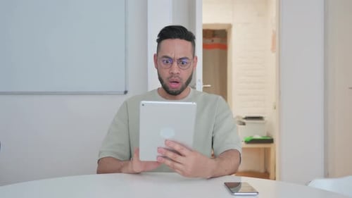 Young Adult Using Tablet Expresses Concern