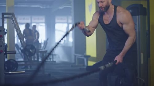 A Pumpedup Athlete Works Out in a Gym with Battle Ropes