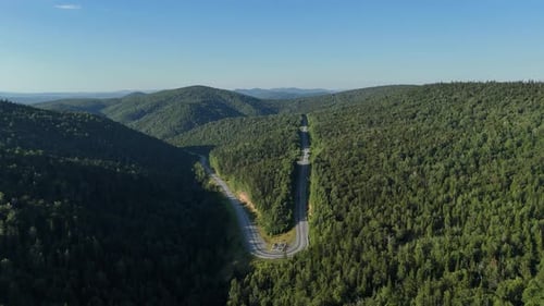 Aerial View Of Mountain Road Through Dense Green Forest