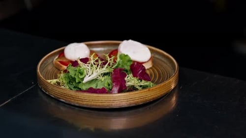 Close Up in a Professional Kitchen on Clean Metal Table a Woman Chef Collects a Salad with Fresh