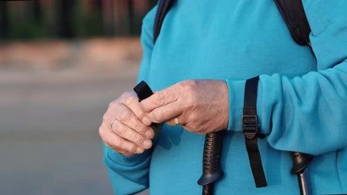 Un vieil homme méconnaissable met à la main une sangle de marche scandinave pour une activité sportive de plein air