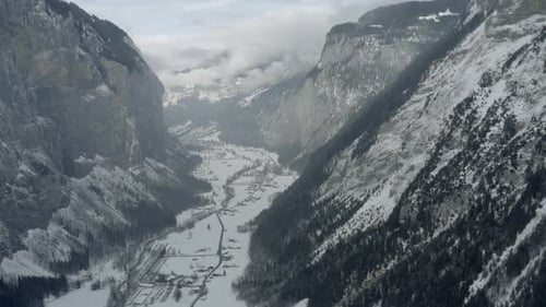Drone Aerial of Lauterbrunnen surrounded by the Mountain Eiger in the swiss alps. The winter in Swit