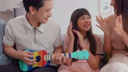 Family Plays Ukulele and Claps Hands at Home