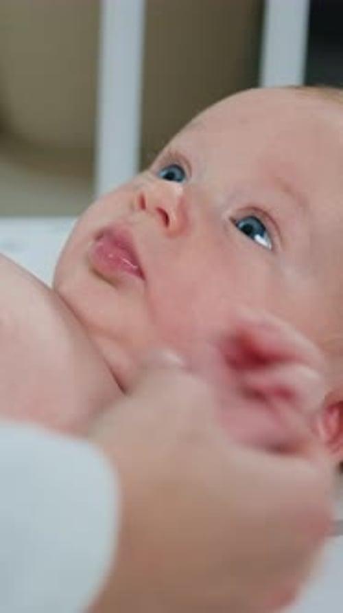Close Up of Female Hands Doing Stomach Massage of Adorable Two Month Baby Boy Little Infant Lying on