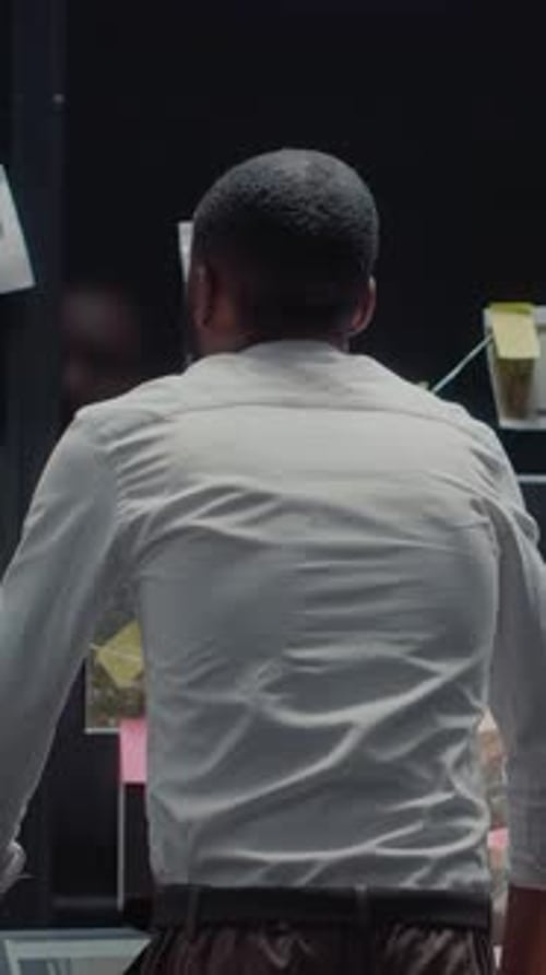 Man Investigating Evidence on a Wall in Office