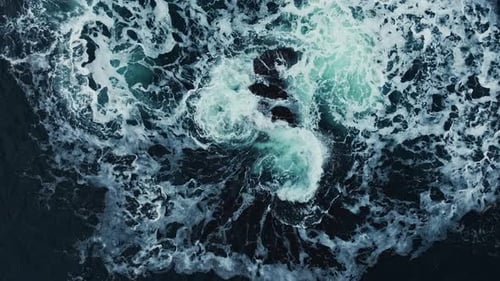 Les eaux de l'océan tourbillonnent autour de la côte rocheuse et pittoresque, les vagues de la mer se brisent sur les rochers