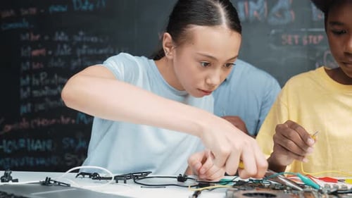 Student use tool fixing board while teacher prepare car robot. Edification