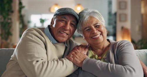 Old couple, face and hug in home for commitment, care and love for comfort in lounge