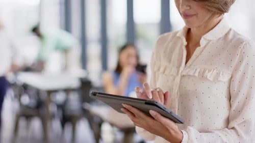 Using tablet, businesswoman working in modern office environment, focusing on task, copy space