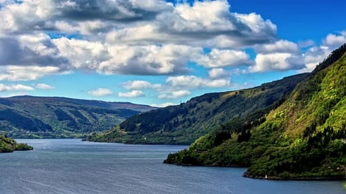 Fast moving video of white clouds moving over a fjord in Norway. View of natural landscape of lovatn