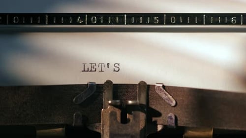 Typewriter Types "Let's Start" Message on Paper
