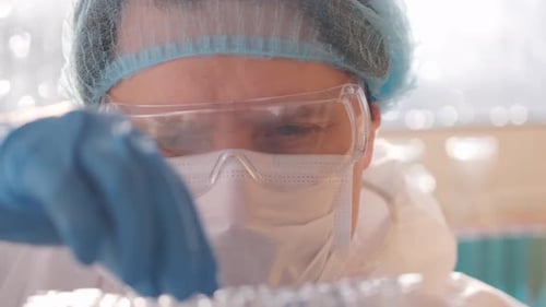 Focused Doctor or Scientist Holding Vial in Lab