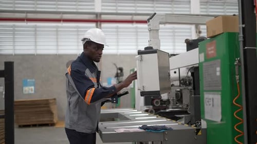 Factory Worker Using Digital Tablet at Corrugated Cutting Machine
