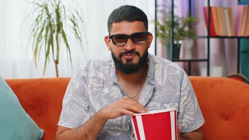 Man Watching Movie and Eating Popcorn at Home