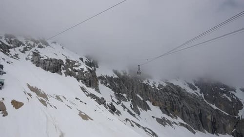 Overlooks the snow-covered ski facilities. Cable car in motion.