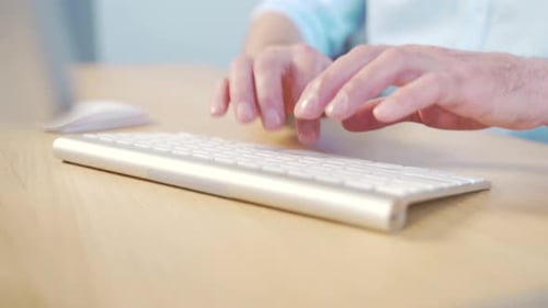 Close-up of a businessmen man's hands typing a desk on a keyboard. Man working on computer at table