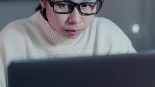 Busy businesswoman working on laptop computer in office.