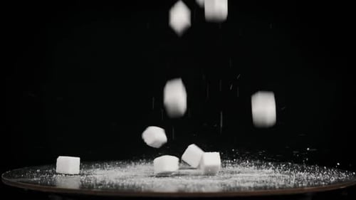 Sugar Cubes Fall on Rotating Table on Black Background in Slow Motion Close Up