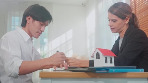 Real estate agent woman and customer man handshake together after agreement success with signing.