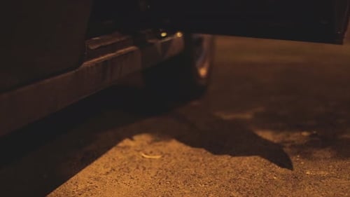 Woman Exiting Car at Night, Close-Up on Legs