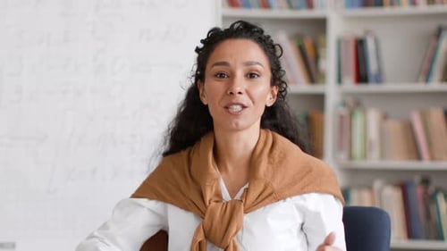 Smiling Woman Explaining Concept Near Whiteboard and Books