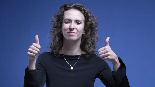 Young Adult Giving Thumbs Up on Blue Background